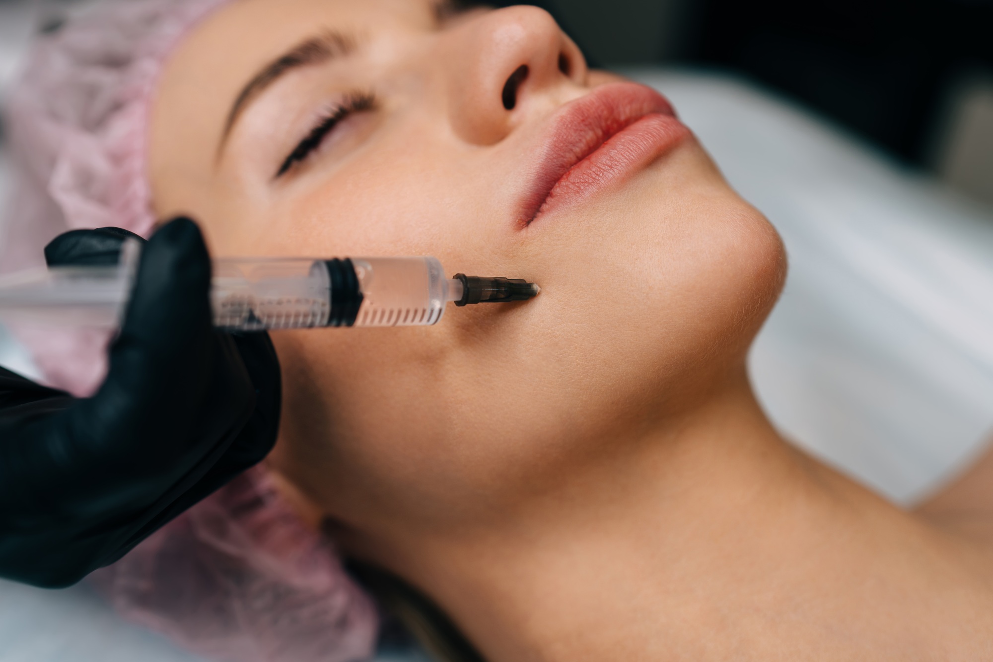 Beautician do botox injection with syringe to girl