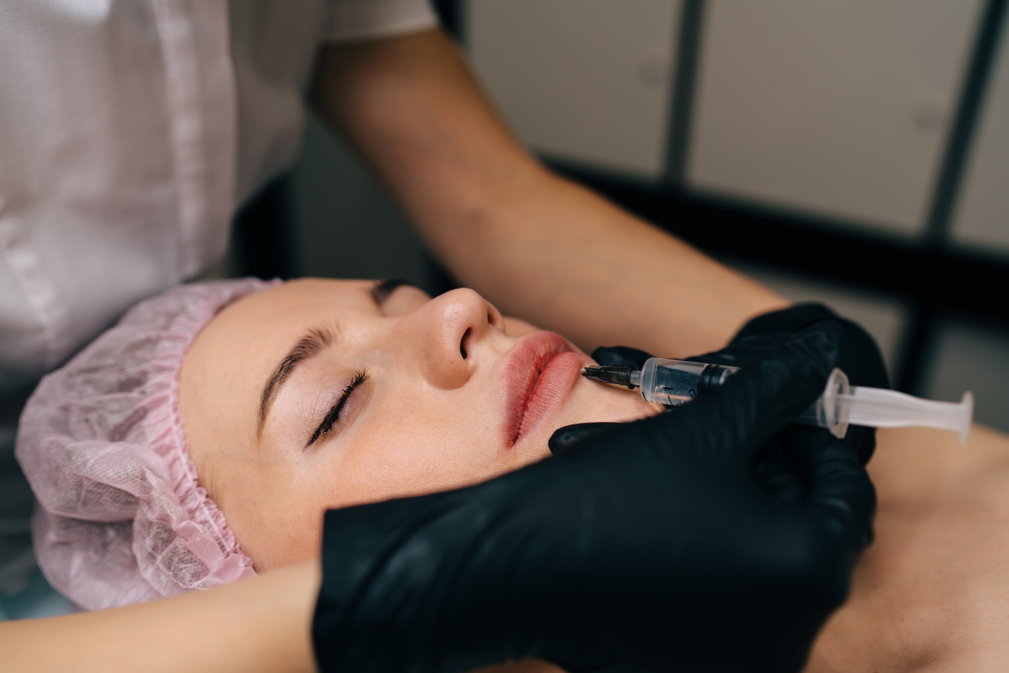 Beautician do botox injection with syringe to girl